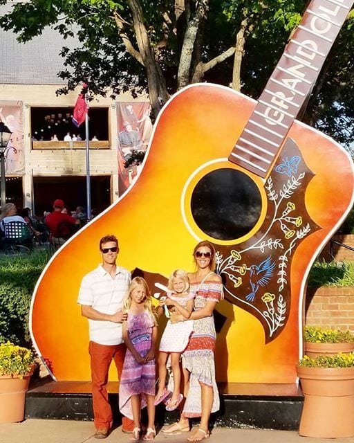 Family photo in front of giant guitar at grand ole opry