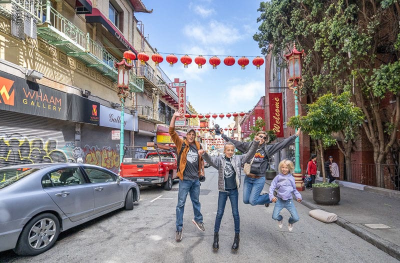 family jumping in streets of Chinatown in San Francisco