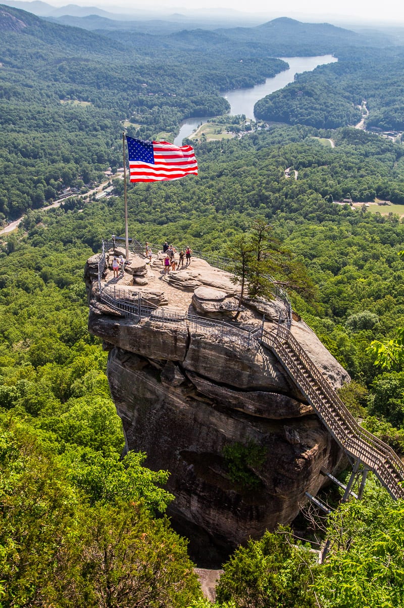 us flag flying on Chimney Rock with views of lake lure behind