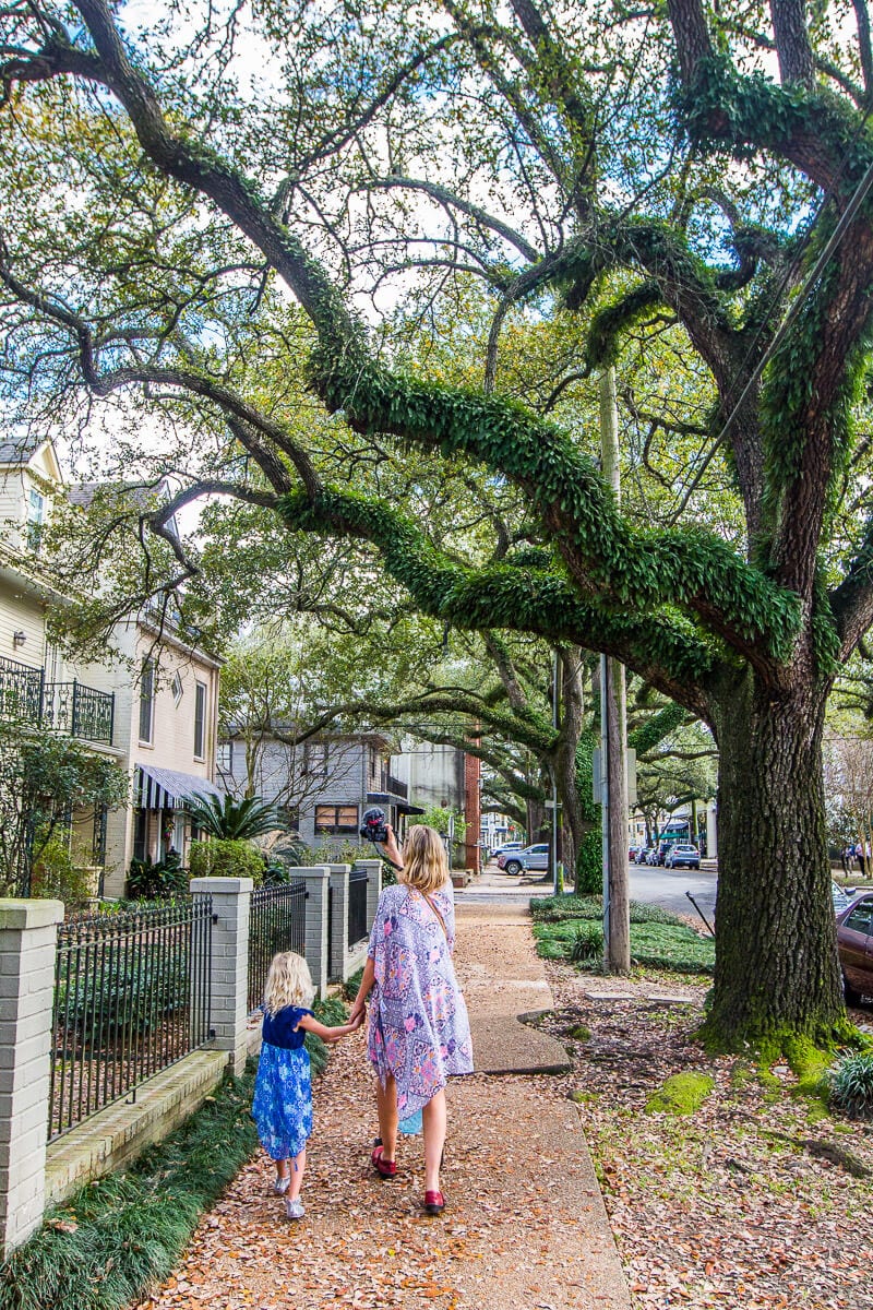 woman and child walking through The Garden District of New Orleans