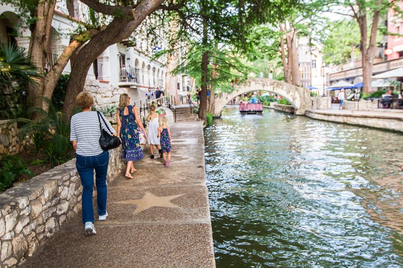 people walking along san antonio riverfront