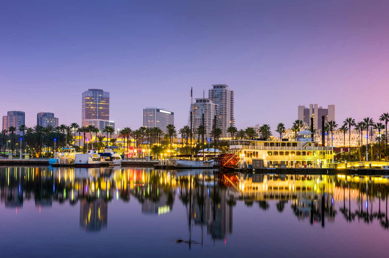 Twilight over Long Beach Marina with its serene waters reflecting the illuminated cityscape, palm trees, and a vintage paddle steamer, creating a picturesque and vibrant evening scene.