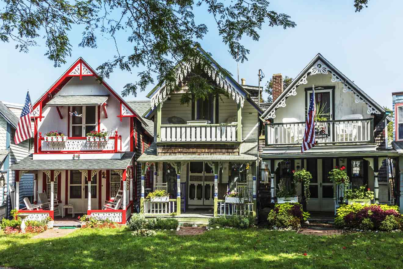 Charming Victorian cottages in Martha's Vineyard with American flags on the porches, exhibiting intricate woodwork and vibrant red and white paint in a lush green setting