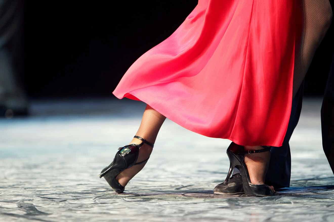 A woman in a red dress and high heels dancing on a stage.