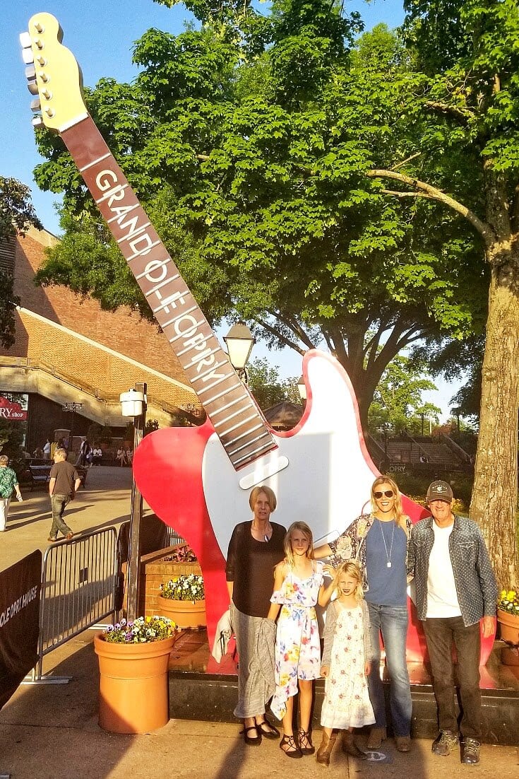 MULTI GEN family posing in front of guitar