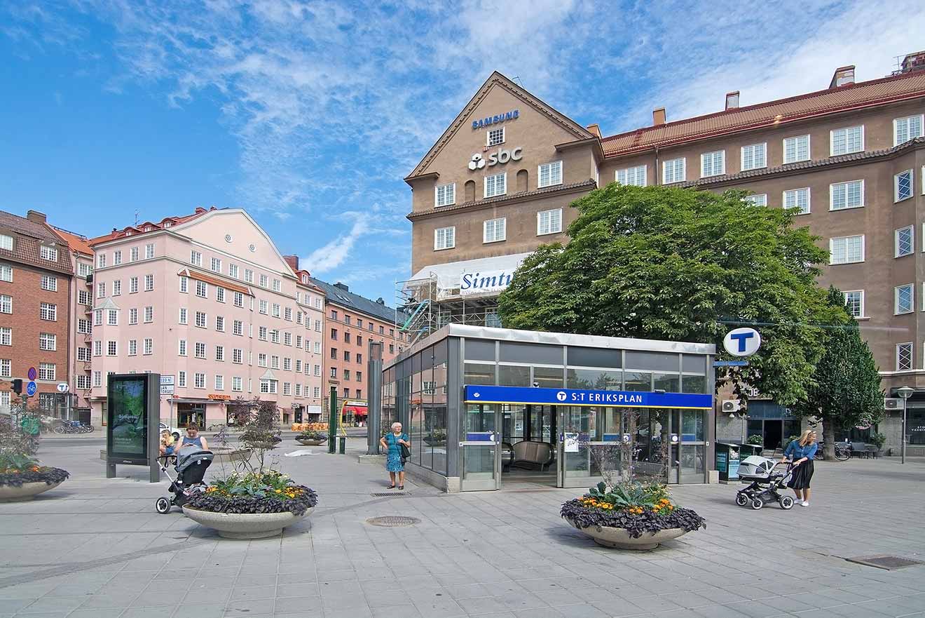 Public square with a metro entrance, flowers, and buildings in Stockholm
