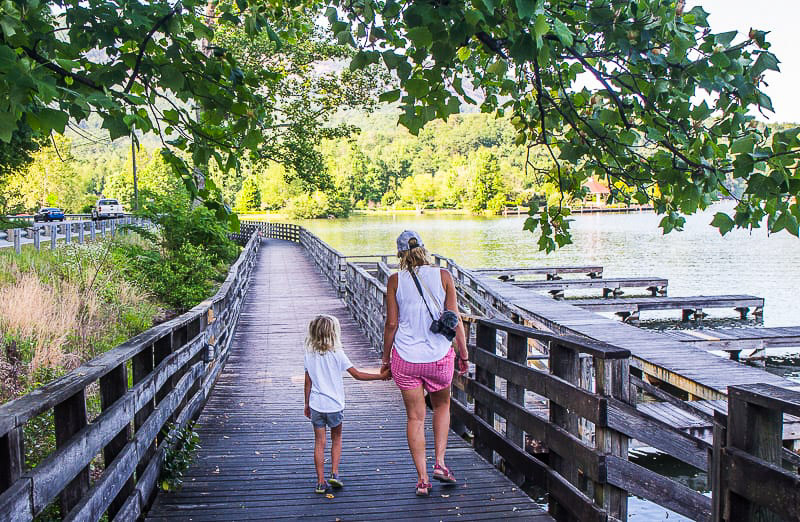 woman and child walking on boardwalk holding hands