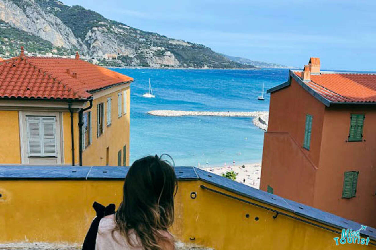 The writer of the post gazes out at the azure waters of the Mediterranean from a high vantage point in Èze, France, with the coastline and a clear sky stretching into the distance