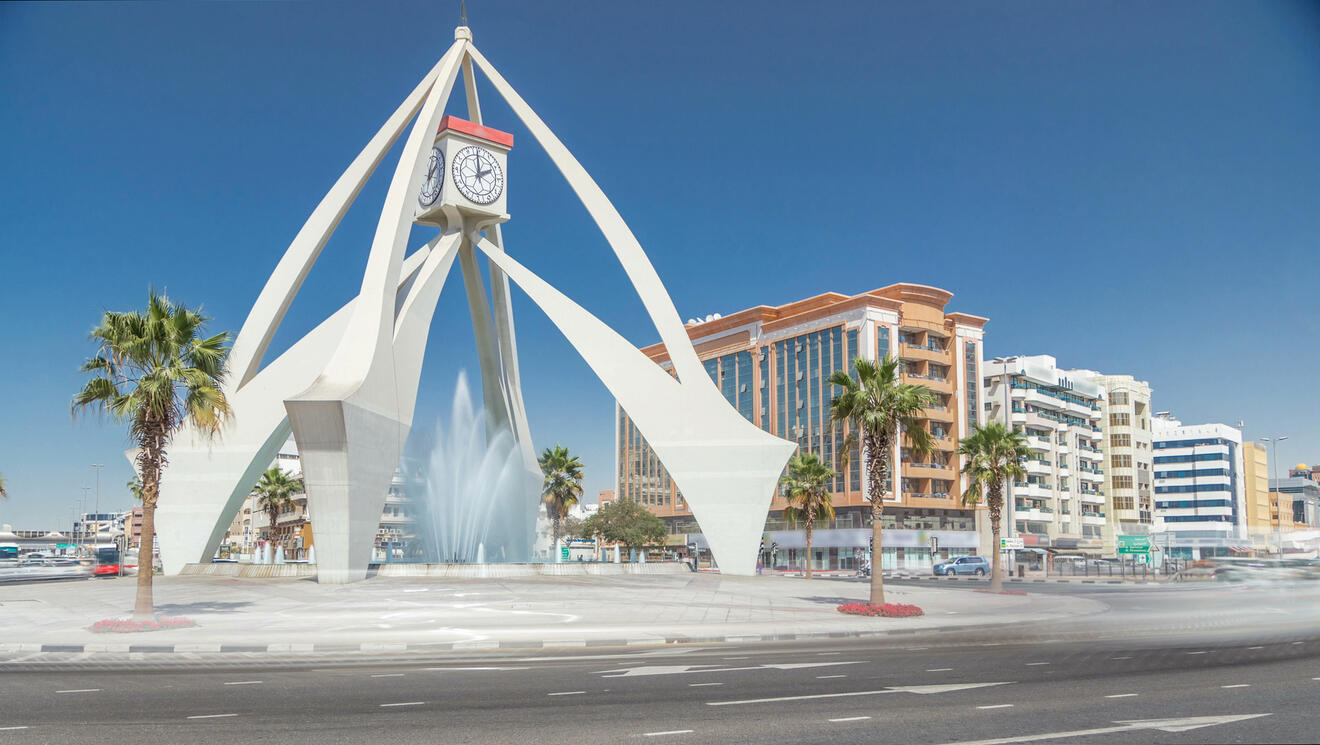 Deira Clocktower, an iconic roundabout landmark, with a water fountain in Dubai during the daytime