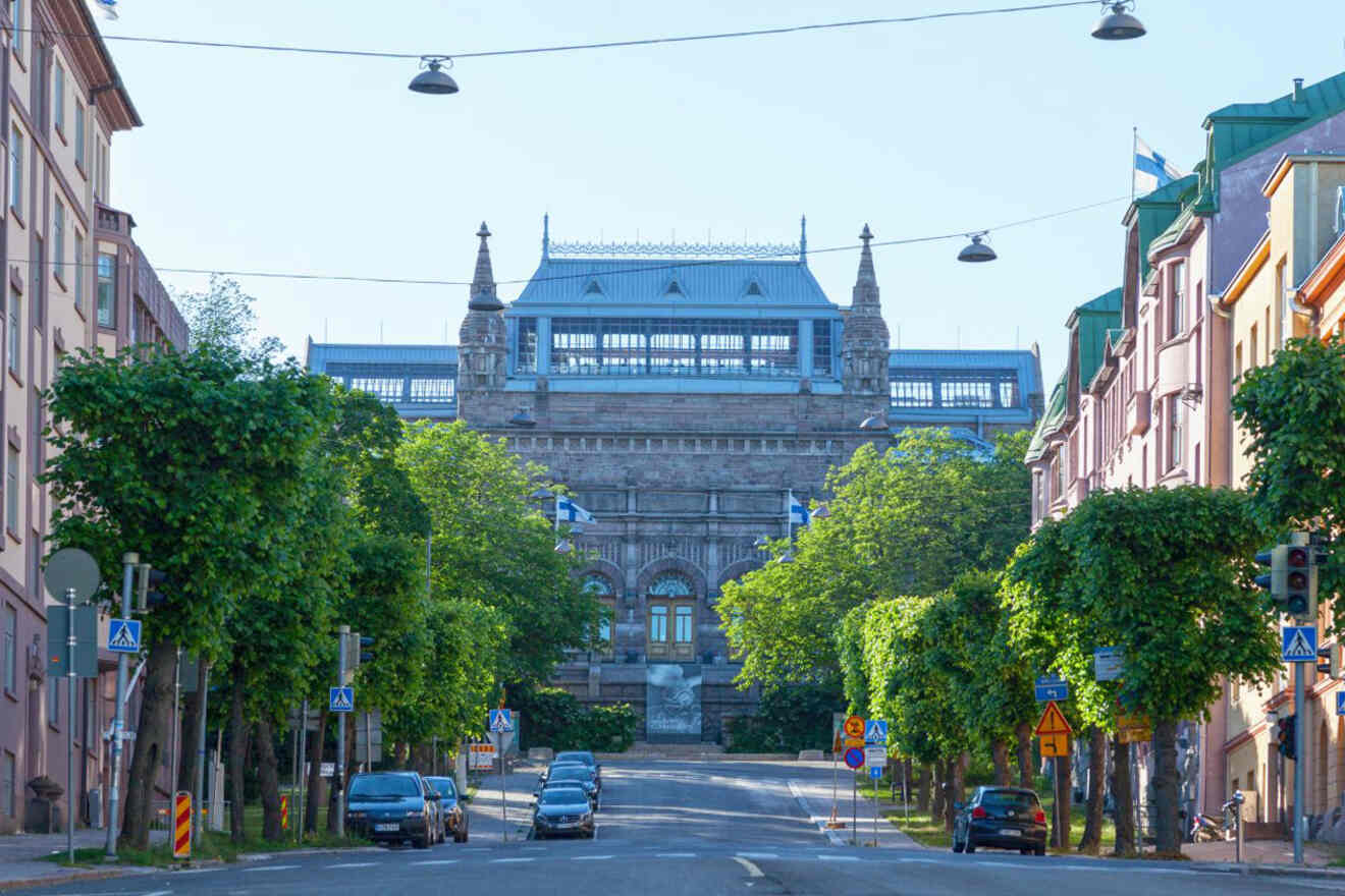 The ornate façade of Turku Art Museum, a distinctive building on a quiet street lined with lush trees under a clear blue sky