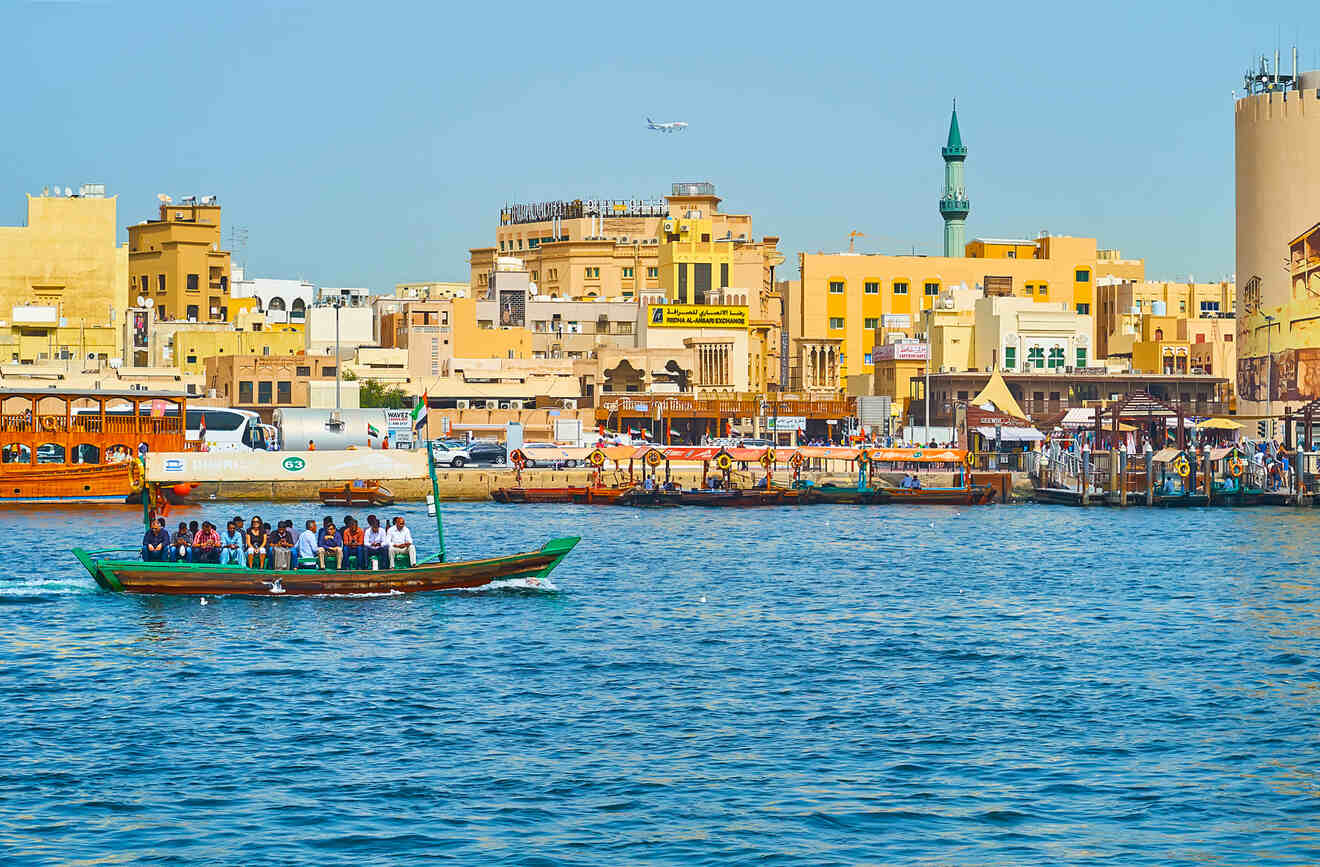 Vibrant scene at Dubai Creek with traditional wooden abras ferrying passengers and historic buildings in the background