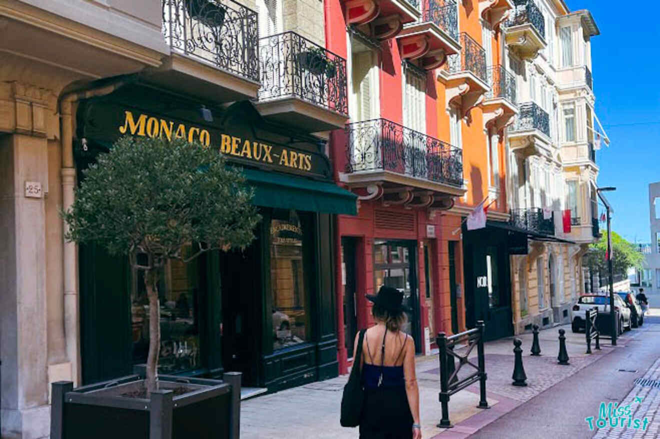 The writer of the post in a summer outfit strolls past the Monaco Beaux-Arts shop, with colorful buildings and balconies in the background