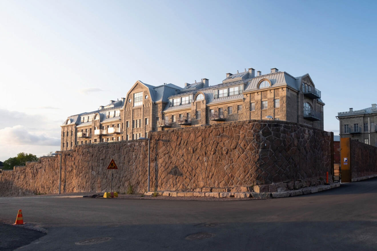 The imposing stone structure of Kakola Prison on a hill in Turku, with its fortified walls and arched windows, on a clear day