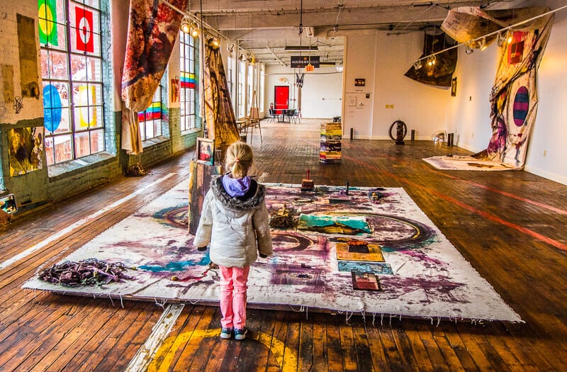 girl standing above painting on floor