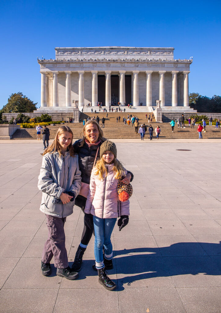 Mom and daughters standing in front monument of Abraham Lincoln