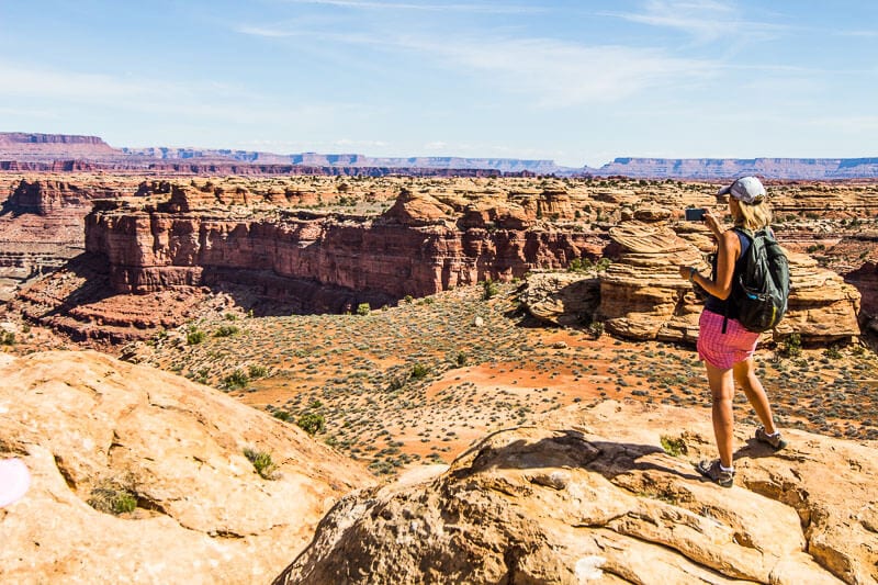 woman taking photos of canyonland vista