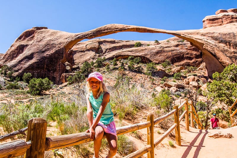 girl sitting in front of rock arches