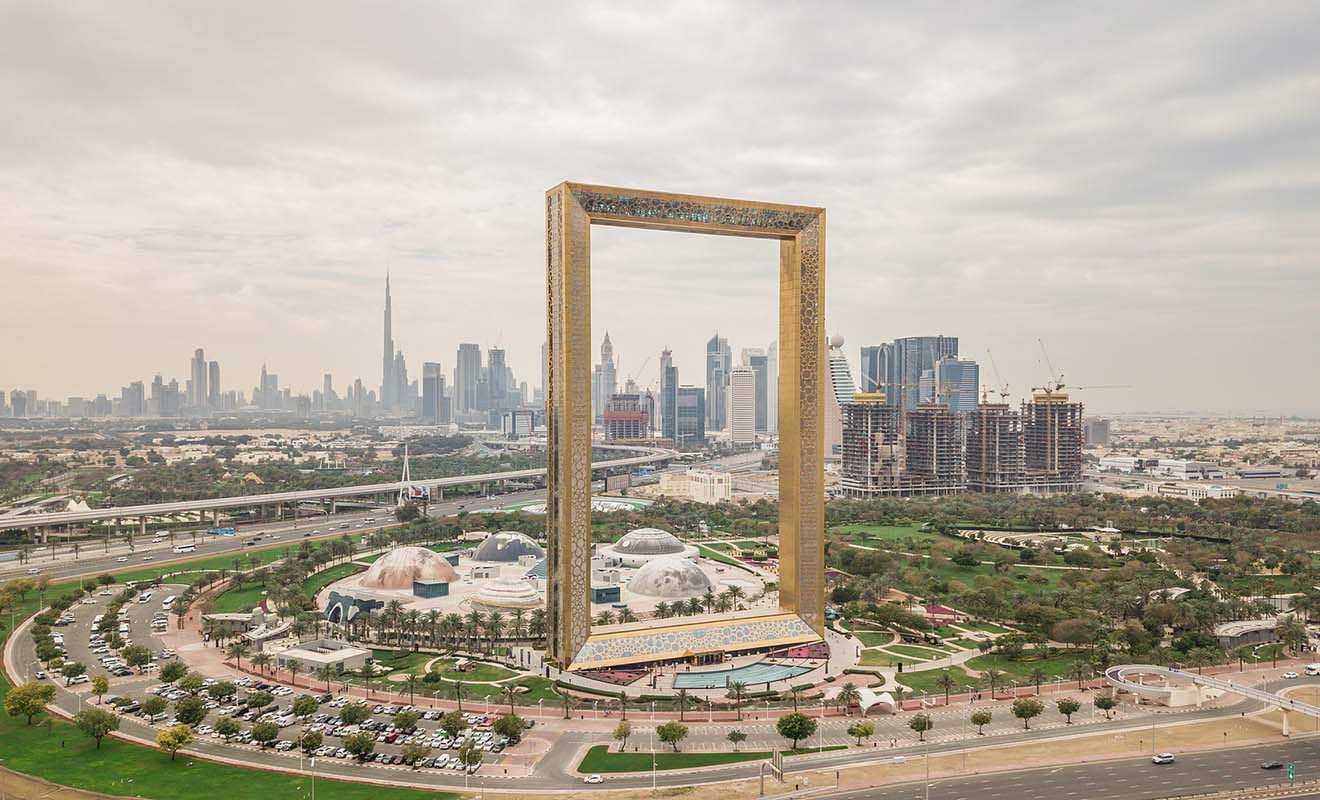 he Dubai Frame, a golden architectural landmark framing city views, with Zabeel Park and the skyline in the background