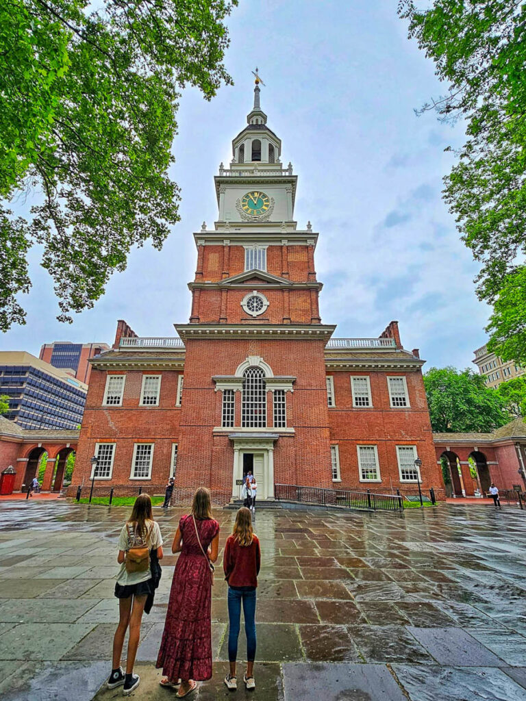 woman and two children looking up at independence hall 