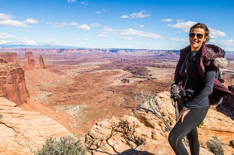 woman standing on edge of cliff with canyon views