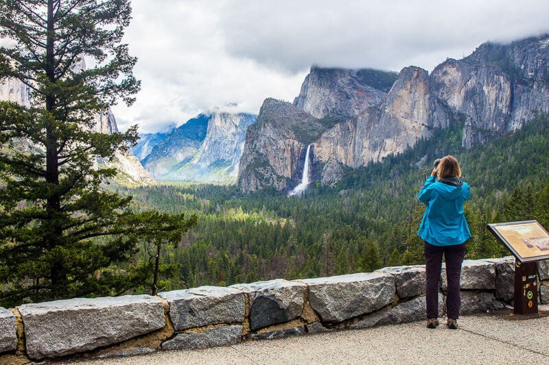 woman taking photo of yosemite valley from tunnel view