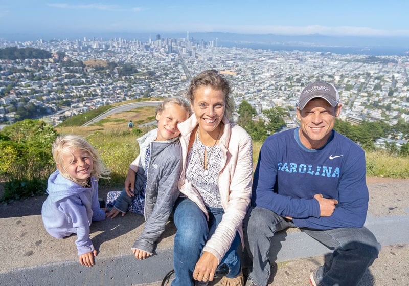 family smiling at twin peaks view san francisco