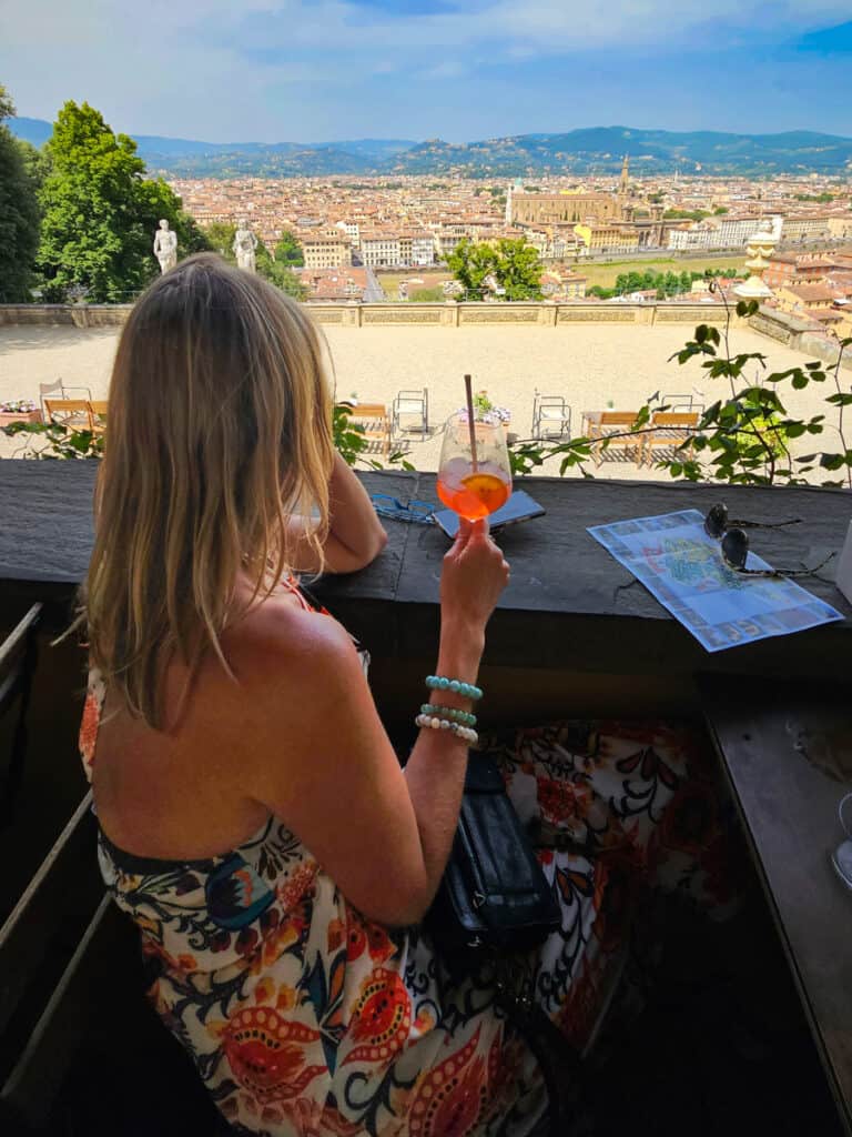 woman looking at views of florence with aperol spritz in hand