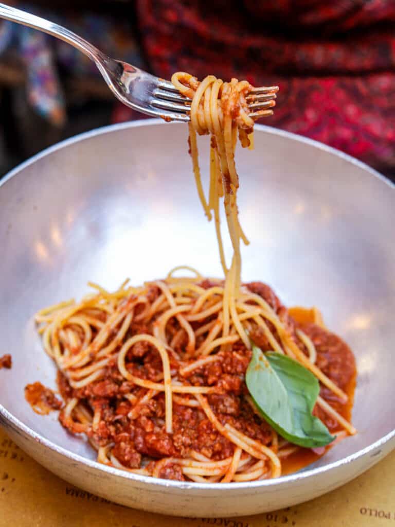 fork holding up twisted spaghetti above a bowl